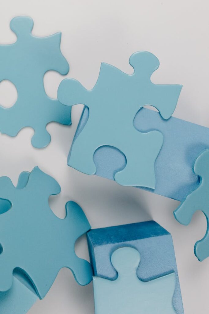 Detailed close-up of blue puzzle pieces randomly arranged on a white background.